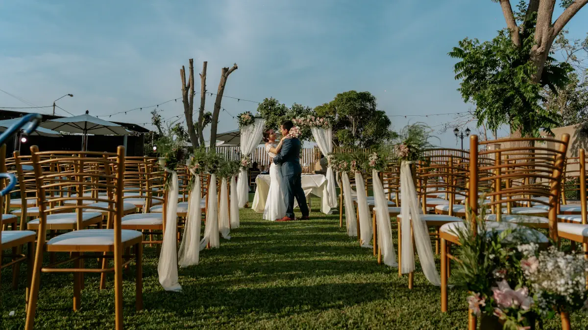 Pareja feliz de novios celebrando su ceremonia civil original y emotiva al aire libre en un jardín de Lima